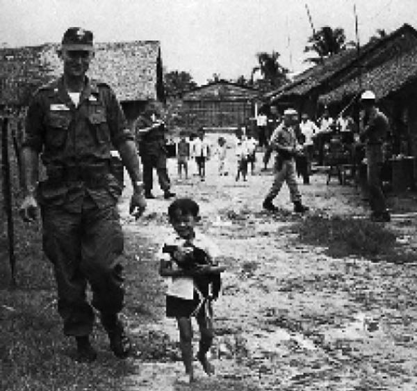 Unidentified U.S. Army adviser and child in the III Corps area north of Saigon, date unknown.
